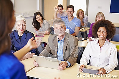 Mature Students In Further Education Class With Teacher Stock Photo