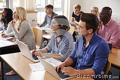 Mature Students Sitting At Desks In Adult Education Class Stock Photo