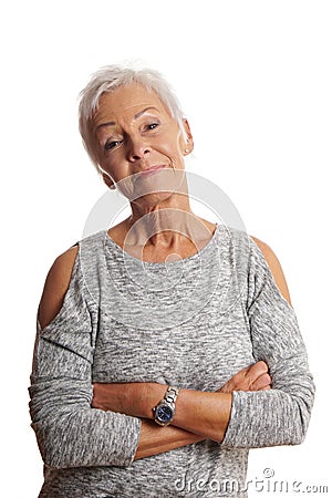 Mature woman with arms folded and head tilted Stock Photo