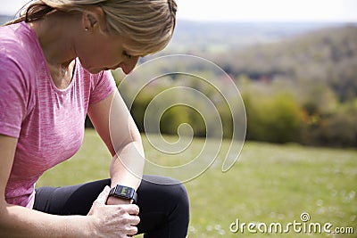 Mature Woman Checking Activity Tracker Whilst On Run Stock Photo