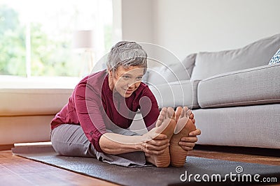 Mature woman doing yoga exercise at home Stock Photo