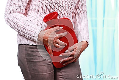 Mature woman with hot bottle and cystitis Stock Photo