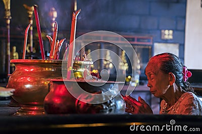 Mature Woman Praying with Incense Stick Editorial Stock Photo