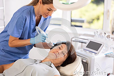 Mature woman receiving facial procedure with hydrogen and oxygen ions attachment Stock Photo