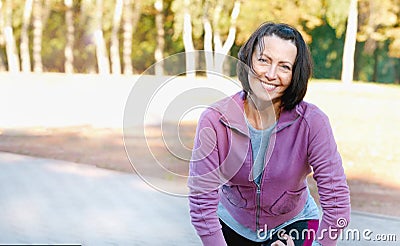 Mature woman runner taking a rest after running in the park Stock Photo