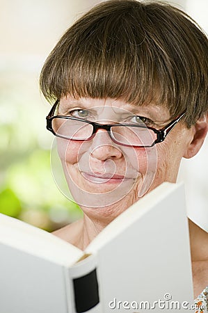 Mature woman with satisfied with book Stock Photo