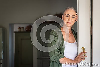 Mature woman standing at door Stock Photo