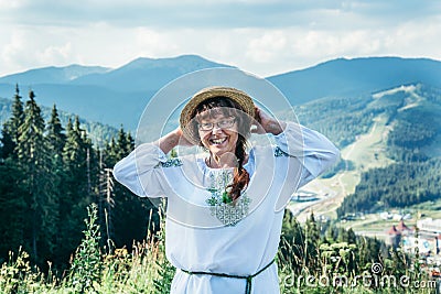 Mature woman stands on the top of the hill and enjoys the view Stock Photo
