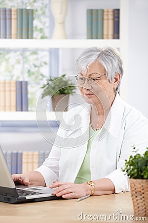 Mature woman working at home on laptop Stock Photo