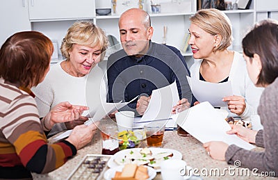 Mature women and their friend are reading documents and talking Stock Photo