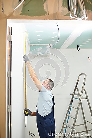 Mature Worker Measuring Wall Stock Photo