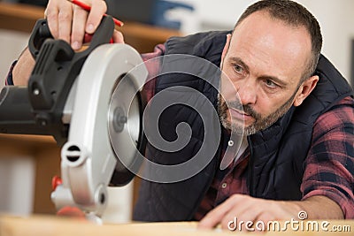 mature workman using circular saw Stock Photo