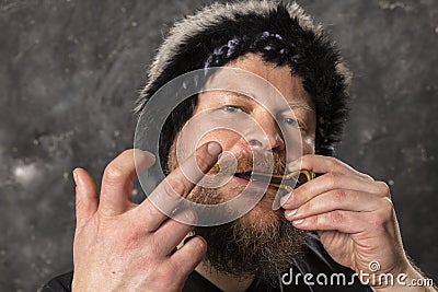 Matured man in fur hat playing jews harp Stock Photo