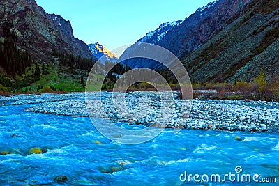 Mauntain valley, canyon. High snow-capped peaks, a river, stormy creek, stream, with blue mineral water. Stock Photo