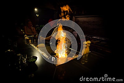 May, 2018 - Ari Atoll, Maldives: Happy teppanyaki chef cooking vegetables at teppan in a Japanese steakhouse on Mishi Sushi Editorial Stock Photo