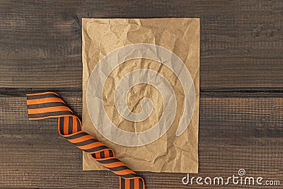 9 May background - George ribbon and note paper on the wooden background. Victory day or fatherland defender day concept. Top view Stock Photo