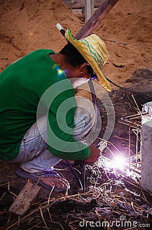 Asian male construction labour do metal welding work at construction site Editorial Stock Photo