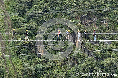 Tourists walking a suspended cable bridge in Ecuador Editorial Stock Photo