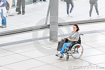 woman with a wheelchair is alone traveling through the exhibition hall at the Bundestag dome Editorial Stock Photo