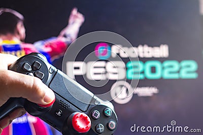 May 17, 2021, Brazil. In this photo illustration the controller for PlayStation PS and in the background the game logo EFootball Cartoon Illustration