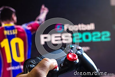 May 17, 2021, Brazil. In this photo illustration the controller for PlayStation PS and in the background the game logo EFootball Cartoon Illustration