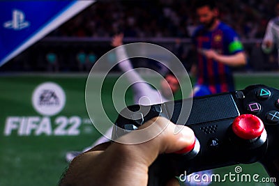 May 17, 2021, Brazil. In this photo illustration the controller for PlayStation PS and in the background the game logo FIFA 22 Cartoon Illustration