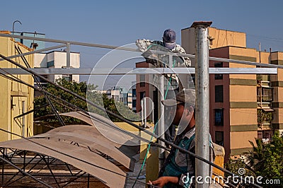 Industrial worker fixing on Home Roof Top Rain Shelter Ulhas Lok Gram Kalyan Maharashtra Editorial Stock Photo