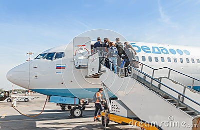 Passengers on the ladder boarding the airplane of the lowcost airline Pobeda Editorial Stock Photo