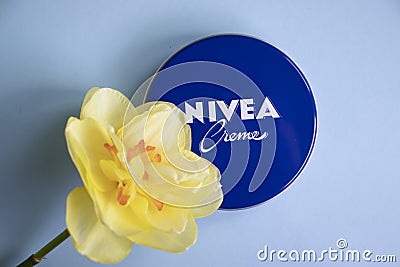 May 1, 2022 Ukraine city Kyiv jar of Nivea beauty product cream, narcissus flower a colored background Editorial Stock Photo