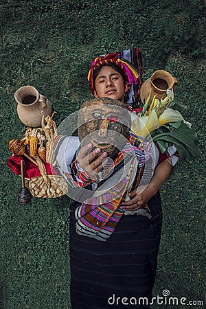 Typical costume woman showing wooden mask lying on grass Editorial Stock Photo