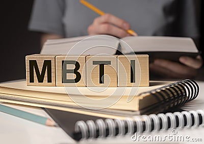 MBTI acronym, word on wood blocks on desk with books. Psychological study and research concept Stock Photo