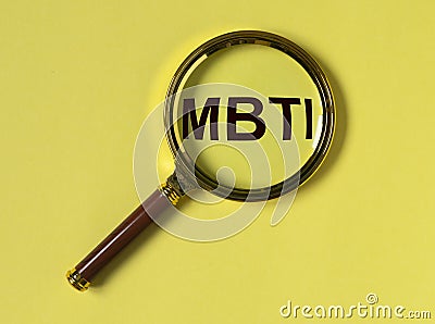 MBTI test of personality types. Acronym through magnifying lens on yellow background. Psychology concept Stock Photo