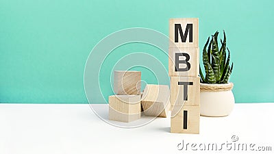 mbti - word is written on wooden cubes on a green background. close-up of wooden elements. In the background is a green Stock Photo