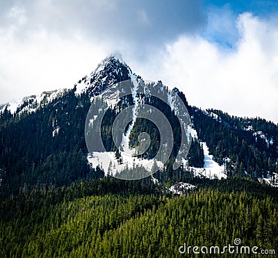 A spring view of McClellan Butte in Washington state with avalanche chutes leading down the flank of the mountain from the peak Stock Photo