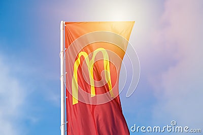 McDonalds red flag with logo of fast food restaurant branch, roadside flow in wind flag with logo Editorial Stock Photo