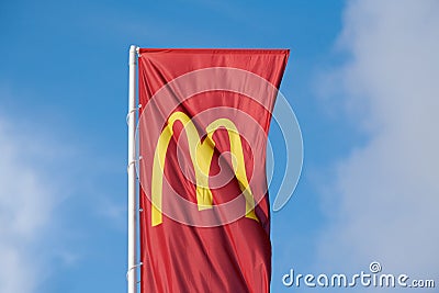 McDonalds red flag with logo of fast food restaurant branch, roadside flow in wind flag with logo Editorial Stock Photo
