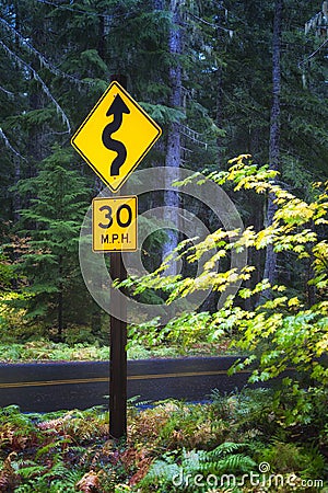 McKenzie Pass road sign to drive slow due to curves Stock Photo