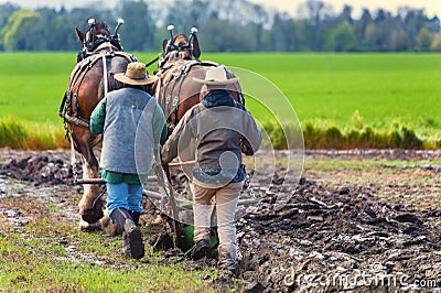 Two women guide a plow pulled by draft horses Editorial Stock Photo