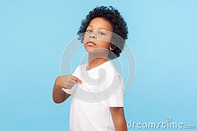 This is me. Portrait of preschool curly boy in T-shirt being proud and arrogant pointing at himself Stock Photo