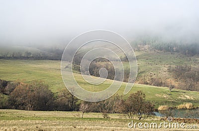 Meadow and hills in fog Stock Photo