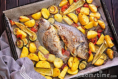 Meal.Baked Dorado fish with vegetables in the oven Stock Photo