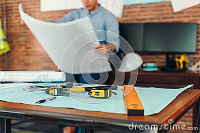 Measure tape, calculate, safety helmet, book on house blue print. Engineering, plaining, drafting tool and equipment concept Stock Photo