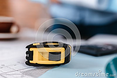 Measure tape, calculate, safety helmet, book on house blue print. Engineering, plaining, drafting tool and equipment concept Stock Photo