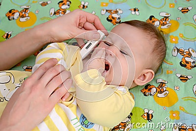 Measurement of temperature to the sick crying baby the electronic thermometer Stock Photo