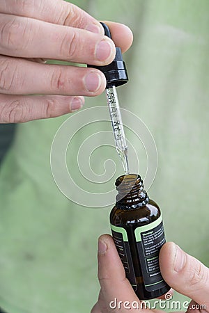 Measuring the correct amount of cbd oil from a brown tincture bottle Stock Photo