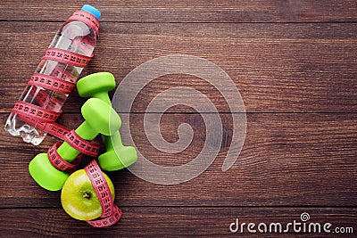 Measuring tape with apples, dumbbells and bottle Stock Photo