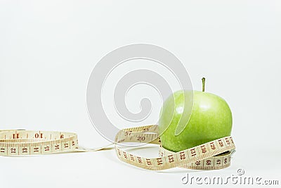 Measuring tape wrapped around a green apple. Stock Photo