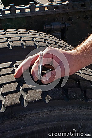 Measuring tread depth tractor-trailer truck tire Stock Photo