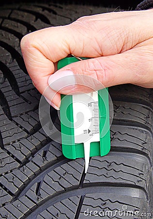 Measuring tread in winter tyre Stock Photo