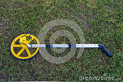 Measuring wheel device laying in the grass Stock Photo